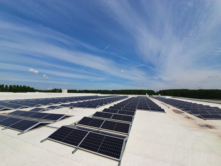 Zonnepanelen geïnstalleerd op het dak van een industrieel gebouw, zorgen voor duurzame energieopwekking voor het bedrijf. zonne-energie